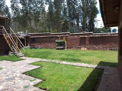 a yard with a brick building and a staircase at Casa rústica Pumayalli in Urubamba