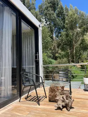 a patio with two chairs and a tree stump at Xaxa Lodge in Tarma