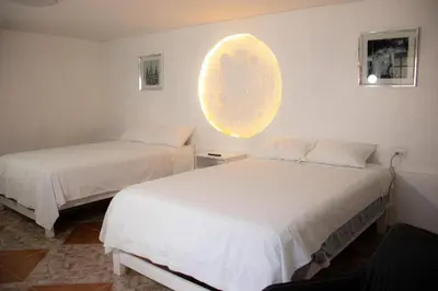 a bedroom with two beds and a orb on the wall at Xaxa Lodge in Tarma