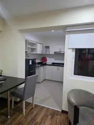 a kitchen with white cabinets and a table and chairs at Barranco blue sea in Lima