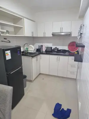 a kitchen with white cabinets and a blue towel on the floor at Barranco blue sea in Lima