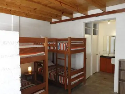 two bunk beds in a room with a kitchen at San Jerónimo River Lodge in Lunahuaná