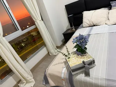a bedroom with a bed with a flower in a box at Departamento frente al mar costa verde in Lima