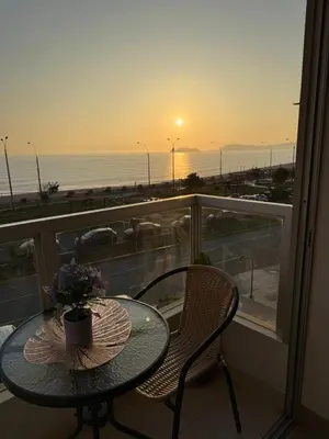 a table and chairs on a balcony with a view of the ocean at Departamento frente al mar costa verde in Lima