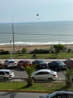 a parking lot with cars parked next to the beach at Departamento frente al mar costa verde in Lima