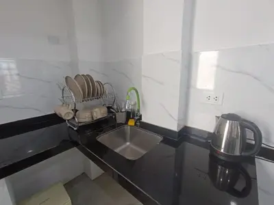 a kitchen with a sink and a counter with dishes at IN FRONT OF THE NEW AIRPORT Hospedaje A y C - Taxi Free - Airport - Apartment Includes breakfast in Lima