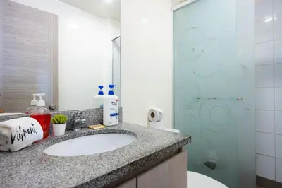 a bathroom with a sink and a glass shower at Centric Apartments by Vibrant in Lima