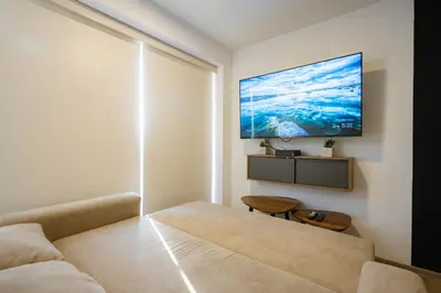 a living room with a couch and a tv on the wall at Centric Apartments by Vibrant in Lima