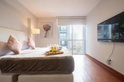 a bedroom with a bed with a tray of food on it at Platino Apartments by Vibrant in Lima
