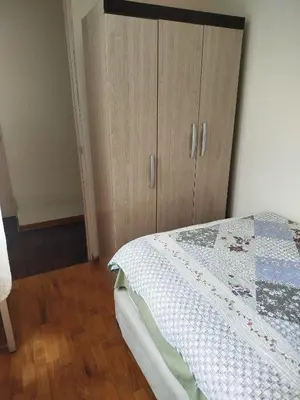 a bedroom with a bed and a wooden cabinet at Like a Home - Barranco in Lima