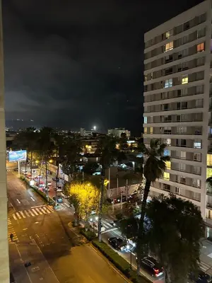 a city street at night with a tall building at Suites Valetine ocean bco in Lima