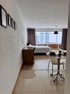 a hotel room with a bed and a table and a bedroom at Alojamiento moderno San Isidro Pet Friendly in Lima