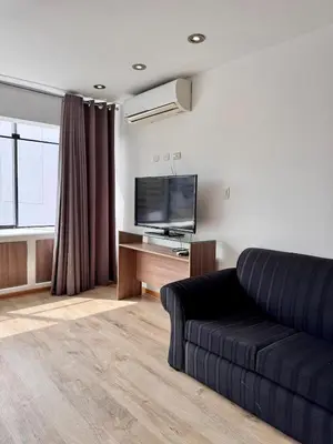 a living room with a couch and a flat screen tv at Alojamiento moderno San Isidro Pet Friendly in Lima