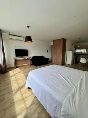 a bedroom with a white bed and a living room at Alojamiento moderno San Isidro Pet Friendly in Lima