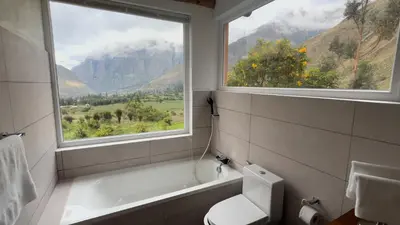 a bathroom with a window and a bath tub and a toilet at Urubamba Luxury Stay 