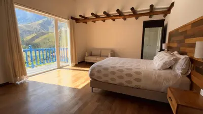 a bedroom with a bed and a large window at Urubamba Luxury Stay 