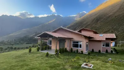 a house on a hill with mountains in the background at Urubamba Luxury Stay 