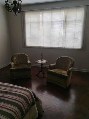a bedroom with two chairs and a table and a window at Amplio Departamento 2 dormitorios in Lima