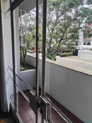 an open door to a balcony with a view of a tree at Amplio Departamento 2 dormitorios in Lima