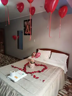 a bed with a heart made out of red balloons at Hotel PRADO'S in Satipo