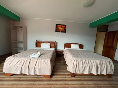 two beds in a hotel room with two bedsvisor at Hotel PRADO'S in Satipo