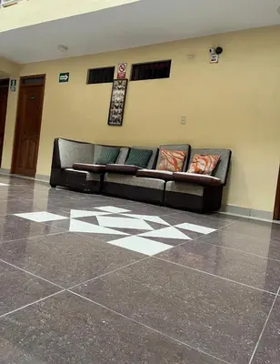 a black couch in a room with a tile floor at Hotel PRADO'S in Satipo