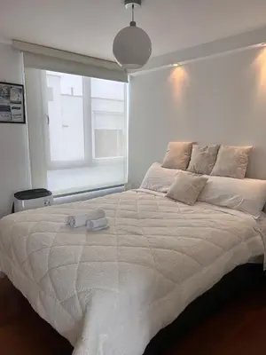 a bedroom with a large bed with two towels on it at Duplex penthouse in Miraflores with terrace in Lima