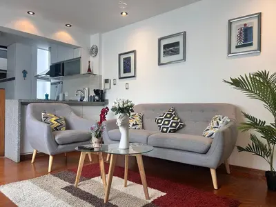 a living room with two couches and a table at Duplex penthouse in Miraflores with terrace in Lima