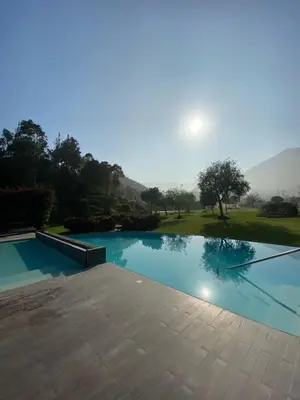 a swimming pool with the sun in the background at Casa de Campo en Cieneguilla in Cieneguilla
