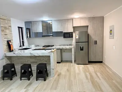 a kitchen with a counter and some black stools at Minidepartamento en Miraflores in Lima