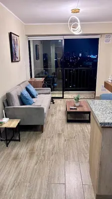 a living room with a couch and a table at 1 dormitorio moderno con balcon a 5 min de parque Kennedy-Miraflores in Lima