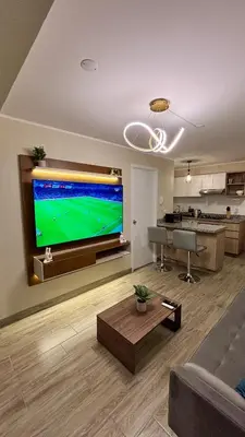 a living room with a large flat screen tv at 1 dormitorio moderno con balcon a 5 min de parque Kennedy-Miraflores in Lima