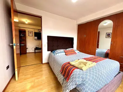 a bedroom with a bed with a blue comforter at Departamento a 5 cuadras de la Plaza de Armas Cusco in Cusco