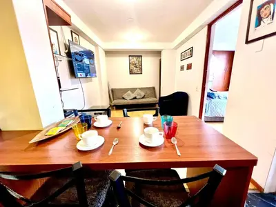 a wooden table with plates and spoons on it at Departamento a 5 cuadras de la Plaza de Armas Cusco in Cusco