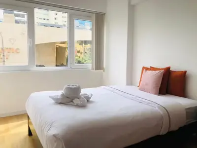 a large white bed in a room with two windows at Boulevard Apartments by Vibrant in Lima