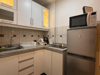 a kitchen with white cabinets and a stainless steel refrigerator at Boulevard Apartments by Vibrant in Lima