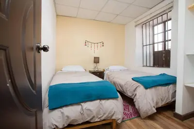 a bedroom with two beds and a window at Departamento a 2 cuadras de la Plaza de Armas in Cusco
