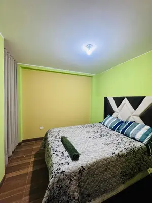a bedroom with a bed with blue and green walls at Departamento 2 Dormitorios, zona tranquila, Ideal 4 Personas El Tambo in Huancayo