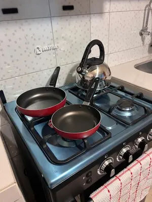 two pots and pans on a stove in a kitchen at Misi House Hostal in Lima