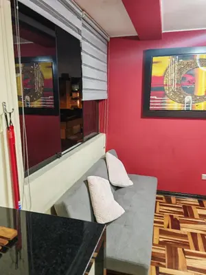 a red room with two chairs and a table at Apartamento Acogedor, tranquilo y privado in Lima