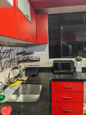 a kitchen with red cabinets and a sink at Apartamento Acogedor, tranquilo y privado in Lima