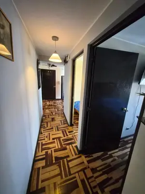 a hallway with a black door and a wooden floor at Apartamento Acogedor, tranquilo y privado in Lima