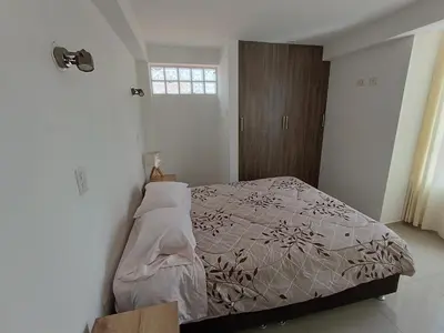 a bedroom with a bed in a white room at Apart El Alba III en Centro Historico de Cusco in Cusco