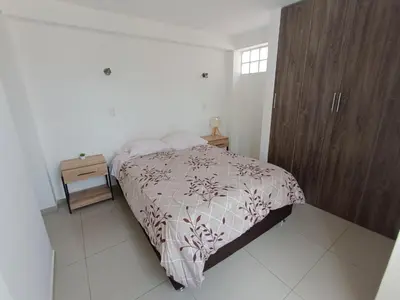 a bedroom with a bed and a wooden cabinet at Apart El Alba III en Centro Historico de Cusco in Cusco