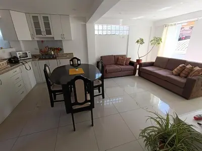 a kitchen and living room with a table and a couch at Apart El Alba III en Centro Historico de Cusco in Cusco