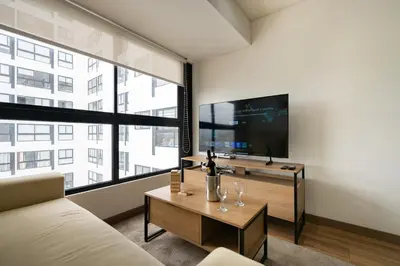 a living room with a couch and a tv and a table at Aquilarias Apartments by Vibrant in Lima
