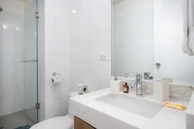 a bathroom with a sink and a toilet and a mirror at Aquilarias Apartments by Vibrant in Lima