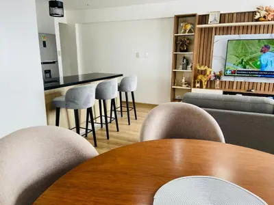 a room with a table and chairs and a television at Moderno Smart Home San Miguel - Self check in in Lima