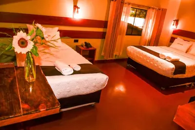 a hotel room with two beds and a table at Hotel Boutique MIRANDO AL SOL in Ollantaytambo