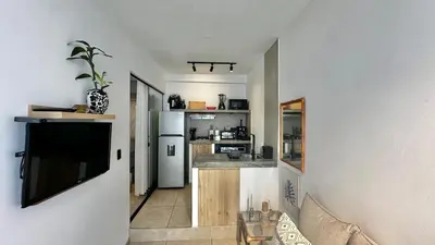 a living room with a television and a kitchen at Luxury mini, beautiful tip in Punta Hermosa